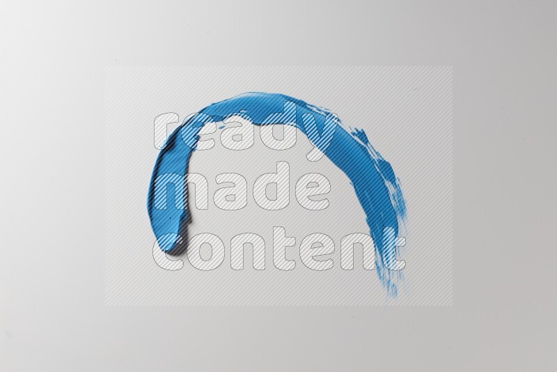 A blue single curved painting knife stroke on a white background