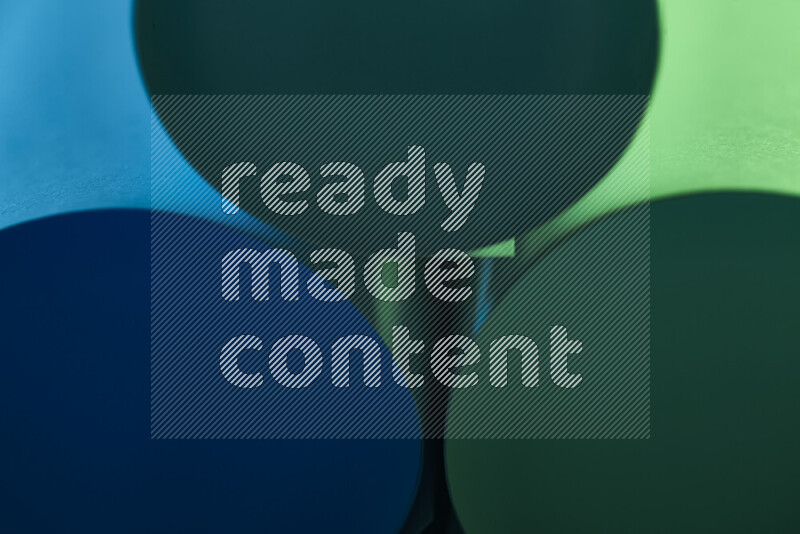 الصورة تعرض فن ورقي تجريدي بأشكال دائرية بدرجات متنوعة من اللون الأخضر والأزرق