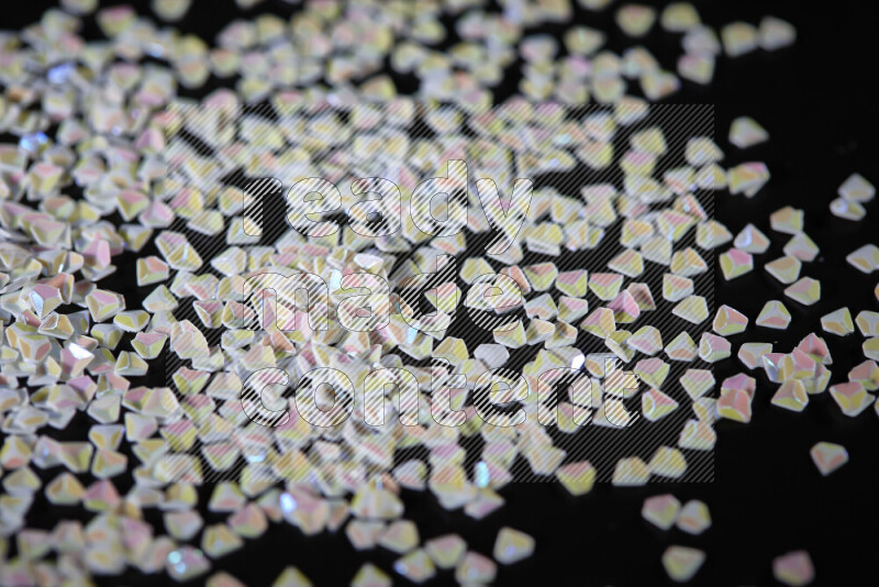 Colorful plastic shards for decoration scattered on a black background