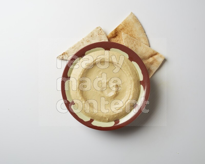 Plain hummus in a traditional plate on a white background