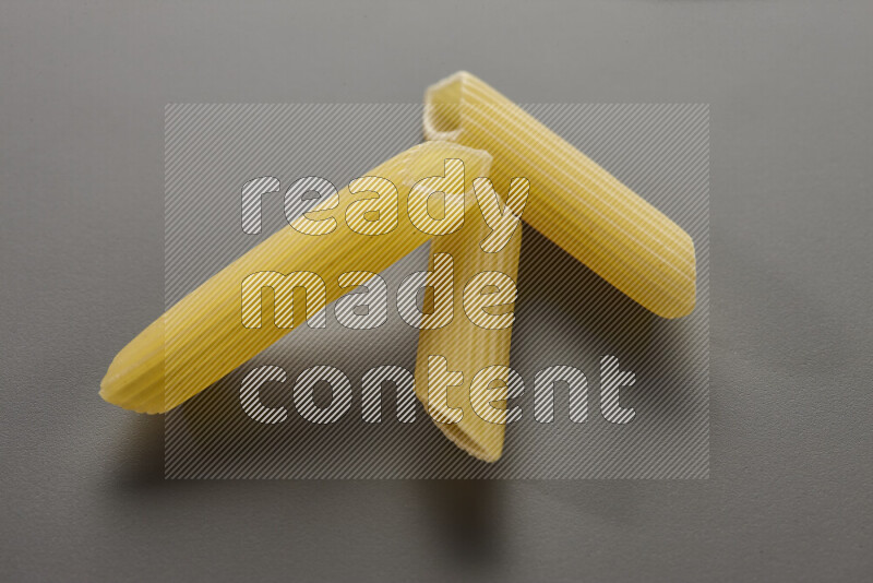 Penne pasta on grey background
