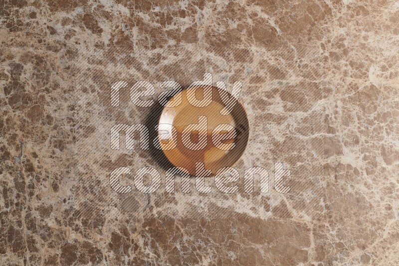 A multicolored pottery plate on beige marble background