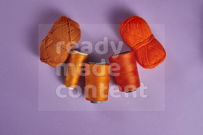 Orange sewing supplies on purple background