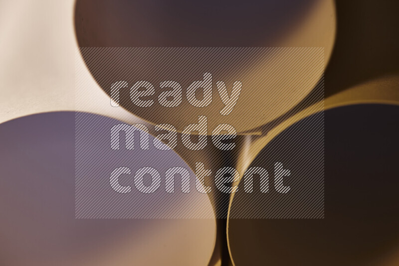 الصورة تعرض فن ورقي تجريدي بأشكال دائرية بدرجات متنوعة من اللون الرمادي والدرجات الدافئة