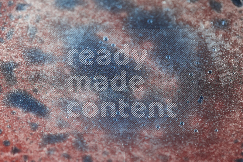 Close-ups of abstract blue watercolor drops on oil Surface on red background