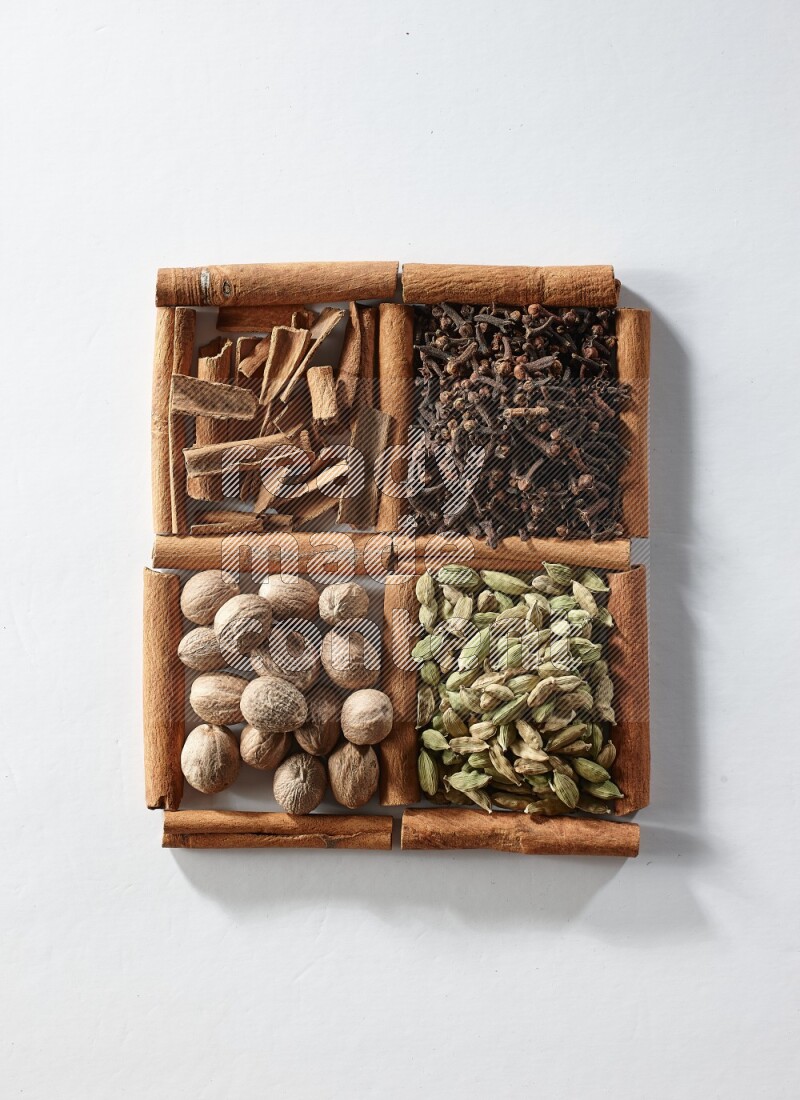 4 squares of cinnamon sticks full of cardamom, cinnamon, cloves and nutmeg on white flooring