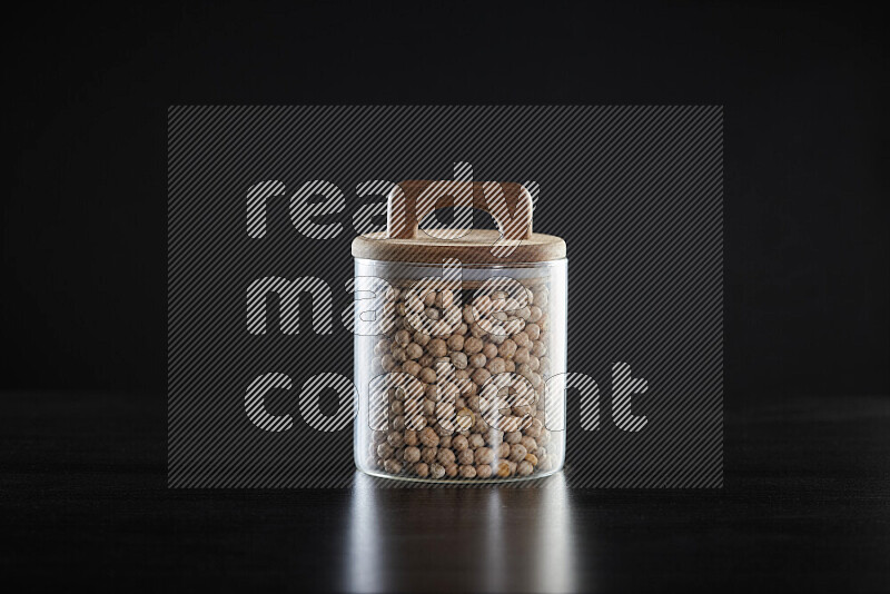 Chickpeas in a glass jar on black background