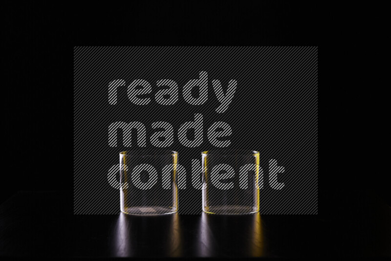 Glassware with rim light in yellow and white against black background