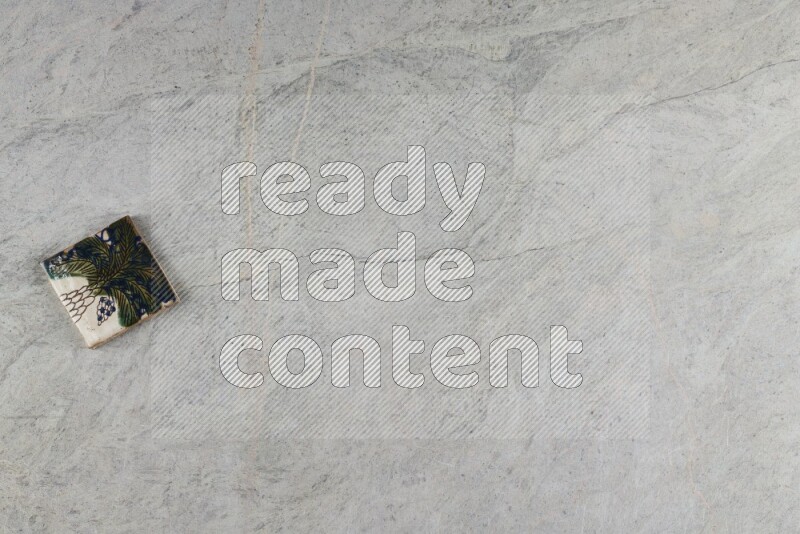 A decorative pottery coaster on grey marble background