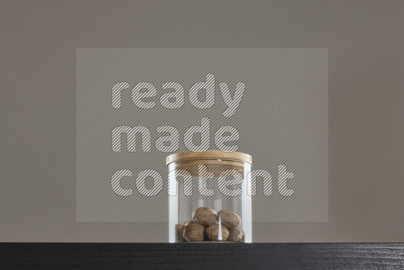 Nutmeg in a glass jar on black background