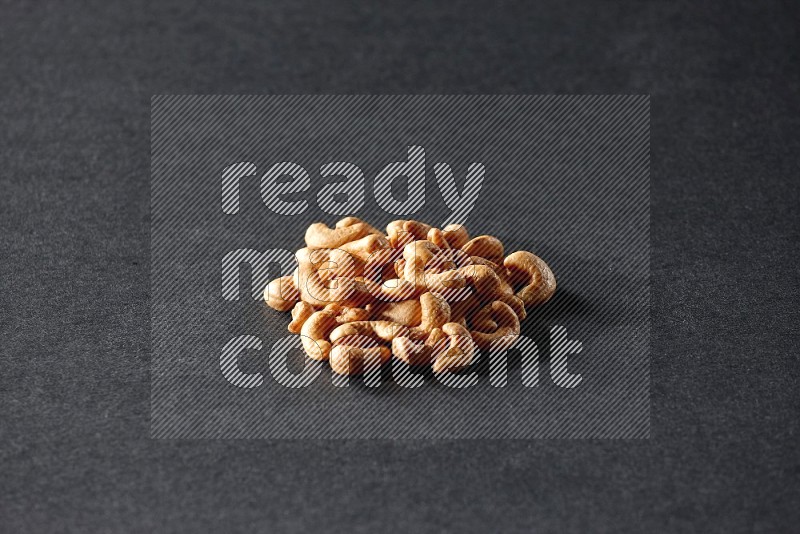 A bunch of cashews on a black background in different angles