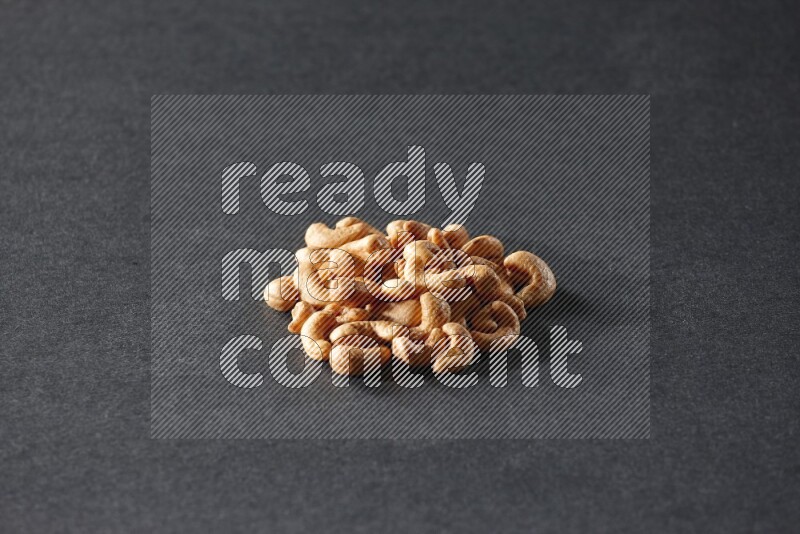 A bunch of cashews on a black background in different angles