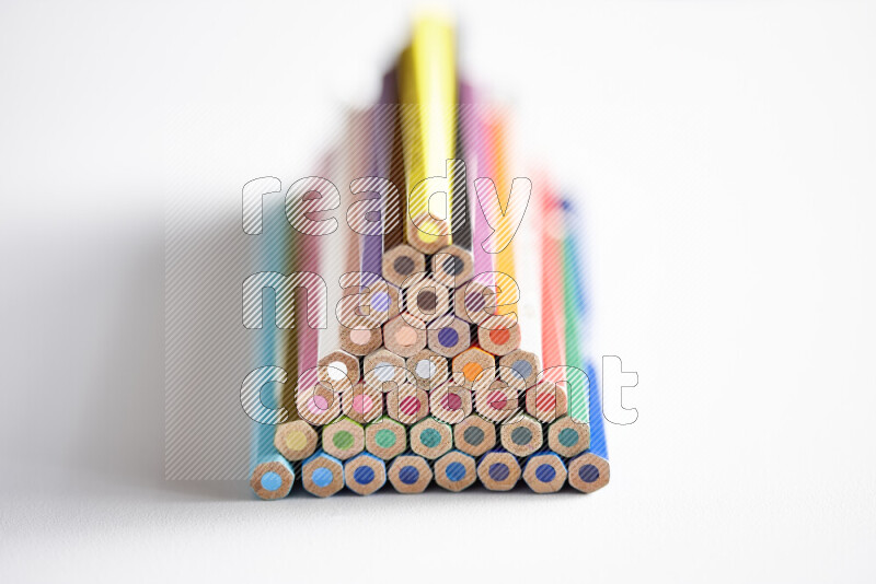 A close-up of the tips of colored pencils arranged in a bundle on white background