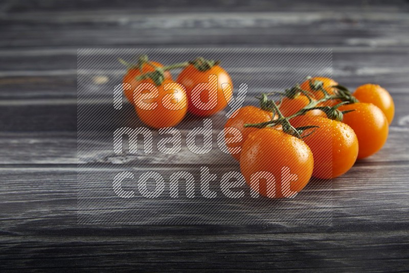 orange cherry tomato vein on a textured grey wooden background 45 degree