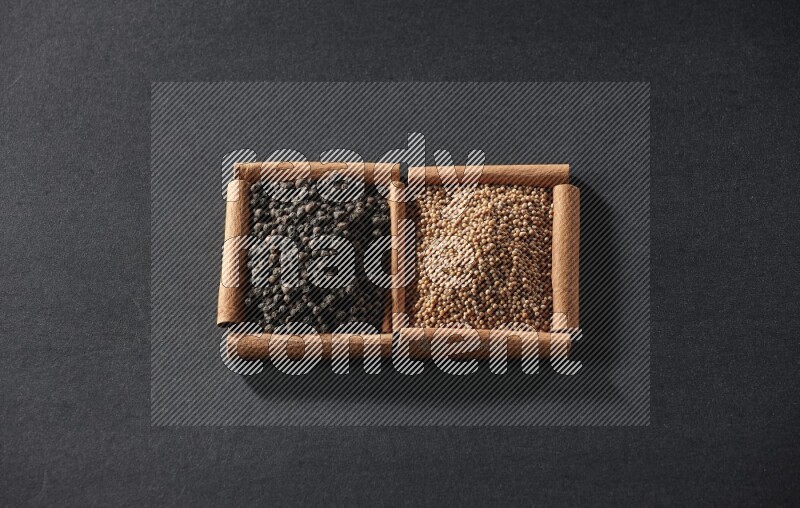 2 squares of cinnamon sticks full of mustard seeds and black peppers on black flooring