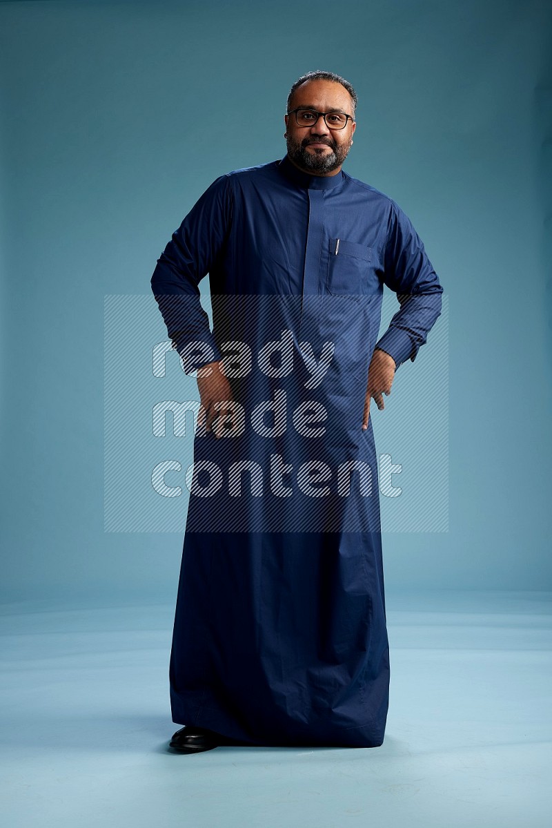 Saudi Man without shimag Standing Interacting with the camera on blue background