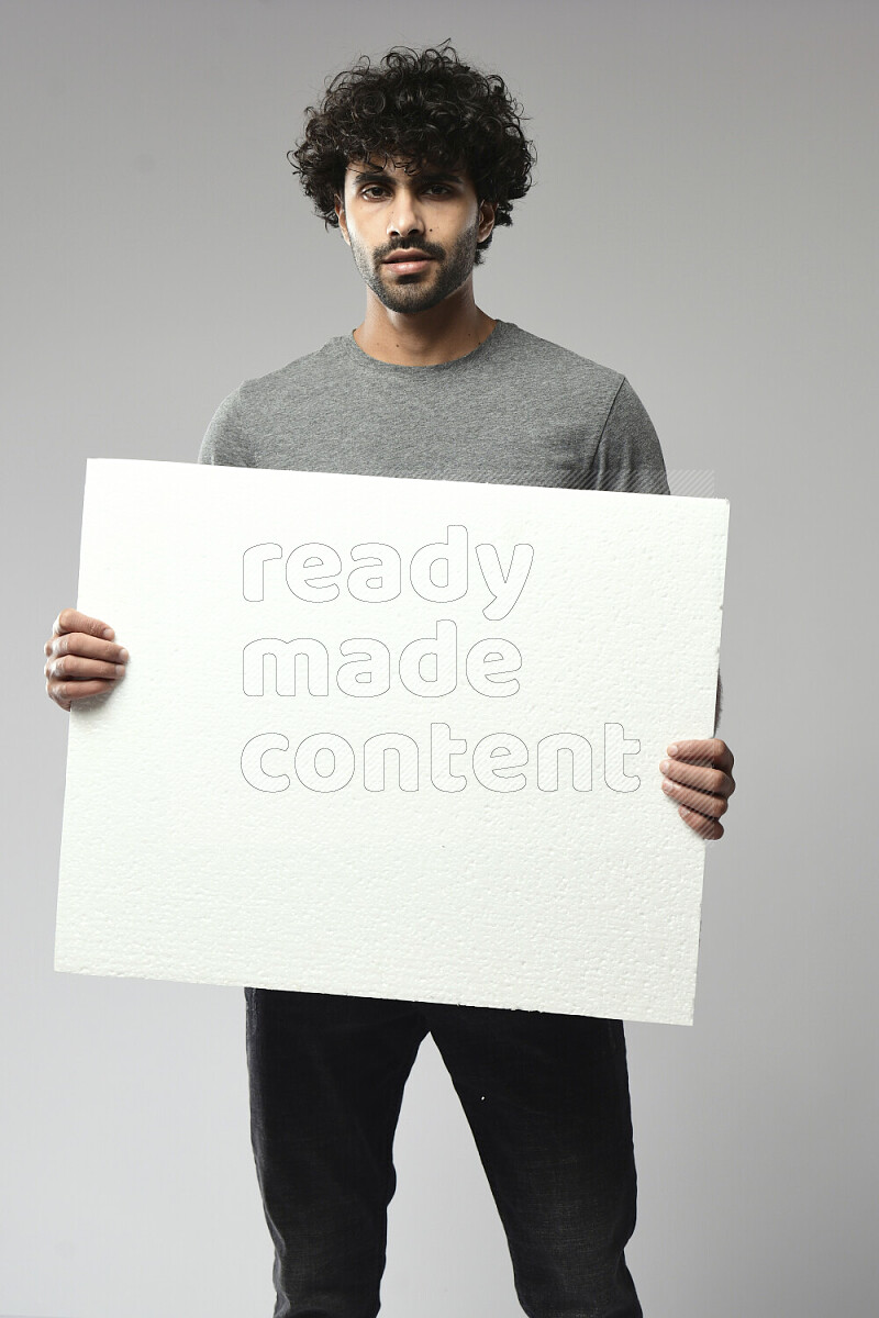 A man wearing casual standing and holding a white board on white background