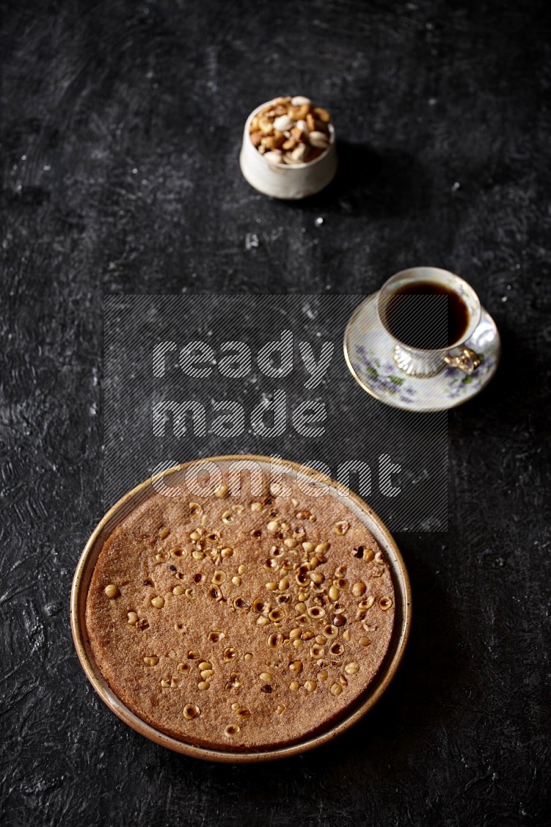 Basbousa with nuts and tea in a dark setup