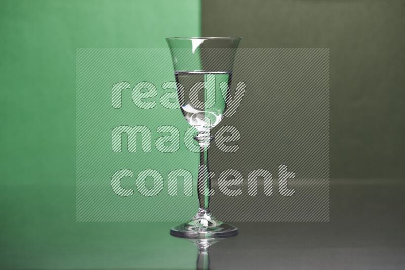 The image features a clear glassware filled with water, set against green and dark green background