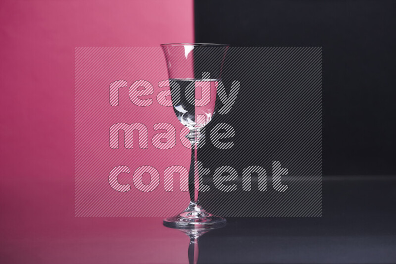 The image features a clear glassware filled with water, set against pink and black background