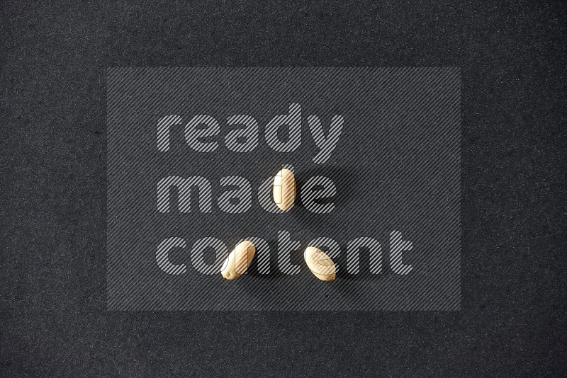 3 peeled peanuts on a black background in different angles