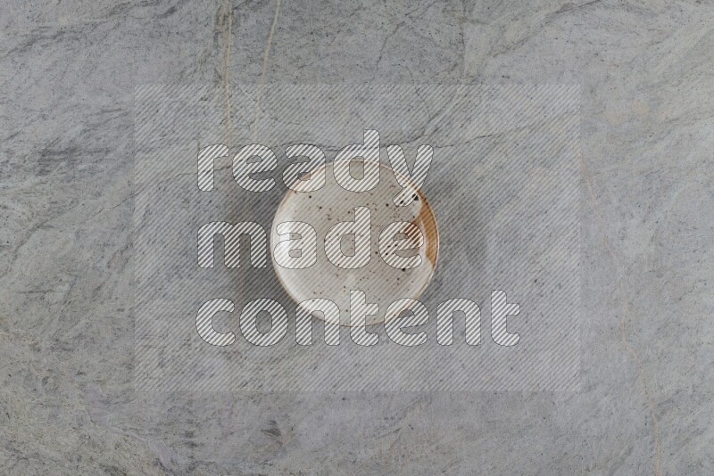 صحن فخاري متعدد الألوان على خلفية من الرخام الرمادي