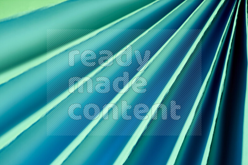 An image presenting an abstract paper pattern of lines in green and blue tones
