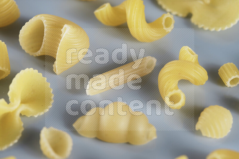 Different pasta types on light blue background