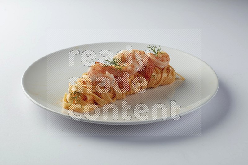 Fettuccini red sauce pasta with shrimp in a white plate on a white background