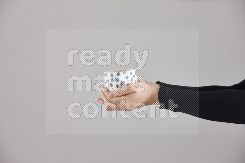 A woman in black abaya holding different pottery essentials in different positions