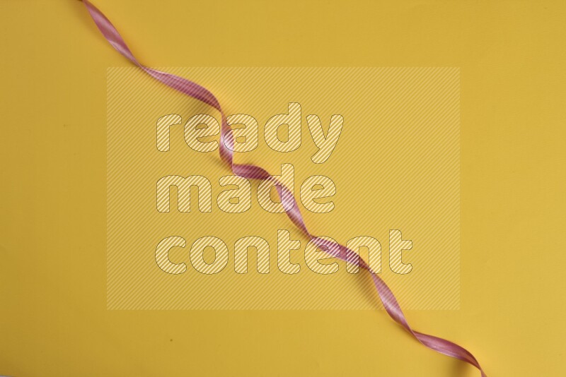 مجموعة من أدوات الخياطة والتفصيل زهرية اللون على خلفية صفراء