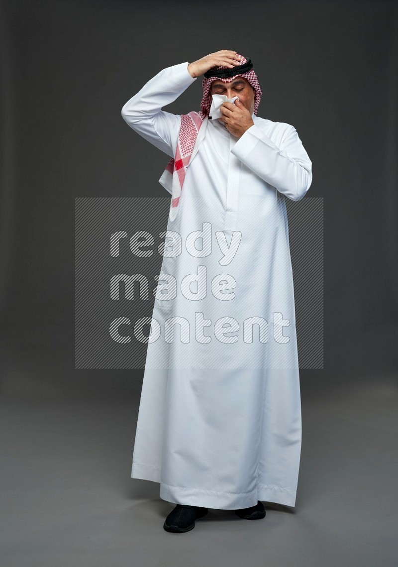 Saudi man with shomag Standing feeling sick on gray background