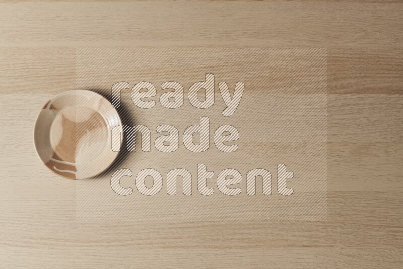 A multicolored pottery plate on light wooden background