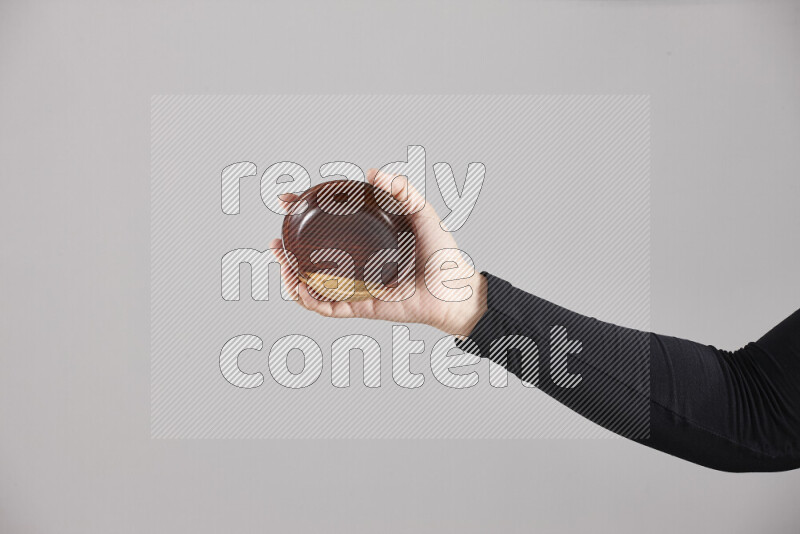 A woman in black abaya holding different wooden essentials in different positions