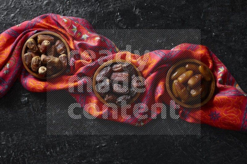 تمر في أطباق خشبية علي خلفية سوداء