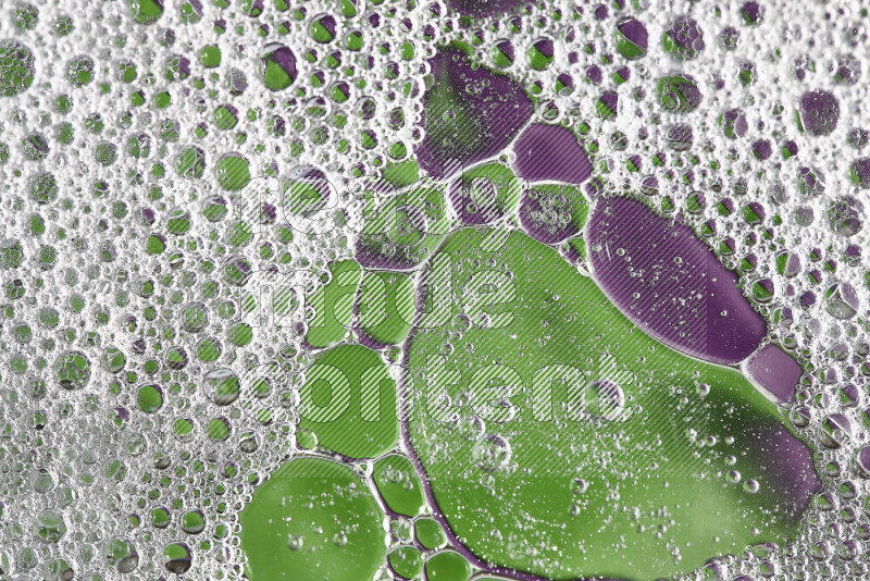 لقطات مقربة لفقاعات الصابون وقطرات الماء على خلفية باللون الأخضر والأرجواني