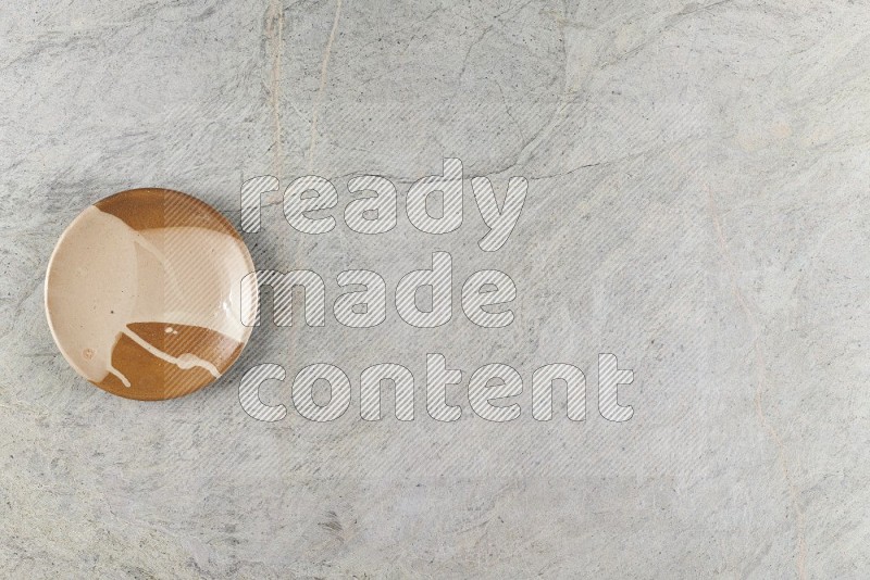 Top View Shot Of A Multicolored Pottery Plate On Grey Marble Flooring