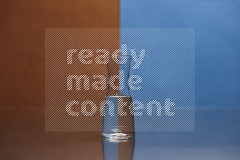 The image features a clear glassware filled with water, set against brown and blue background