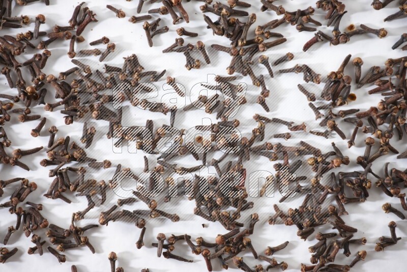 Cloves spread on white flooring