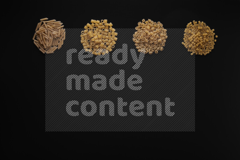 Different pasta types in 4 bunches on black background