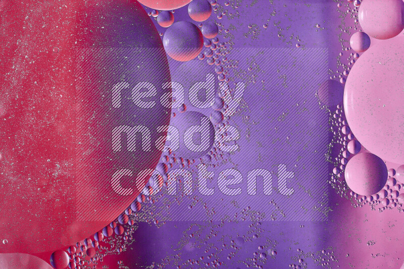 Close-ups of abstract oil bubbles on water surface in shades of red, purple and pink