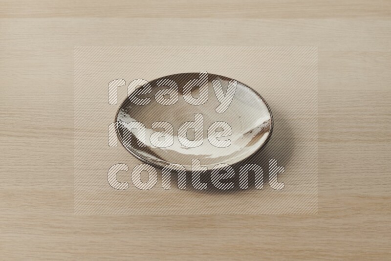 A multicolored pottery plate on light wooden background