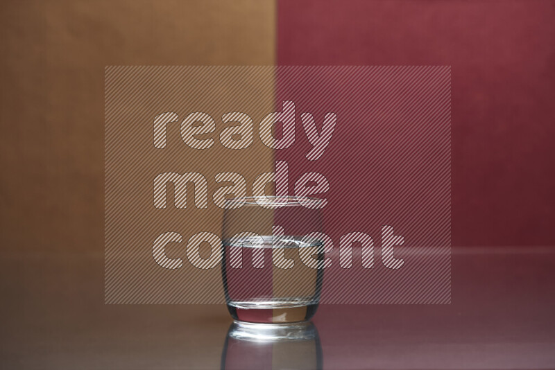 The image features a clear glassware filled with water, set against brown and dark red background