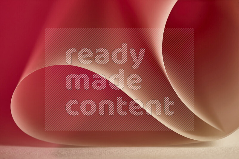 An abstract art piece displaying smooth curves in gold and red gradients created by colored light