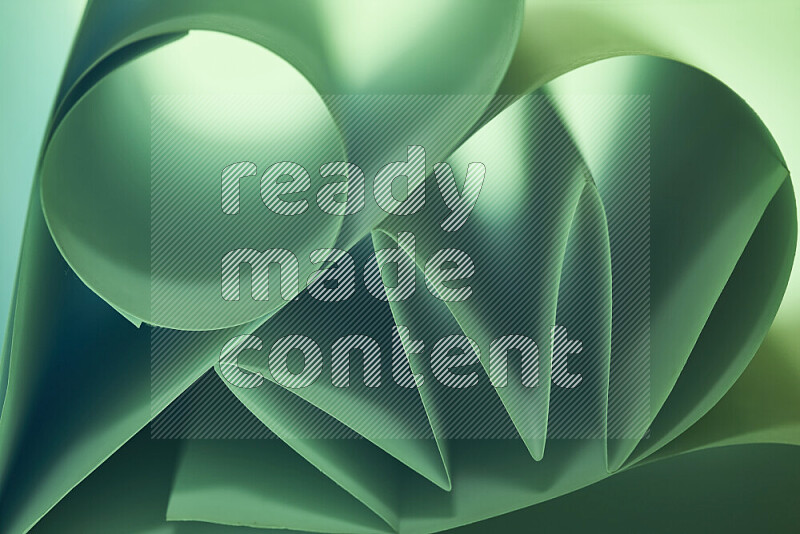 عرض فني لطيات الورق تخلق مزيج من الأشكال الهندسية، مضاءة بإضاءة ناعمة بدرجات اللون الأخضر