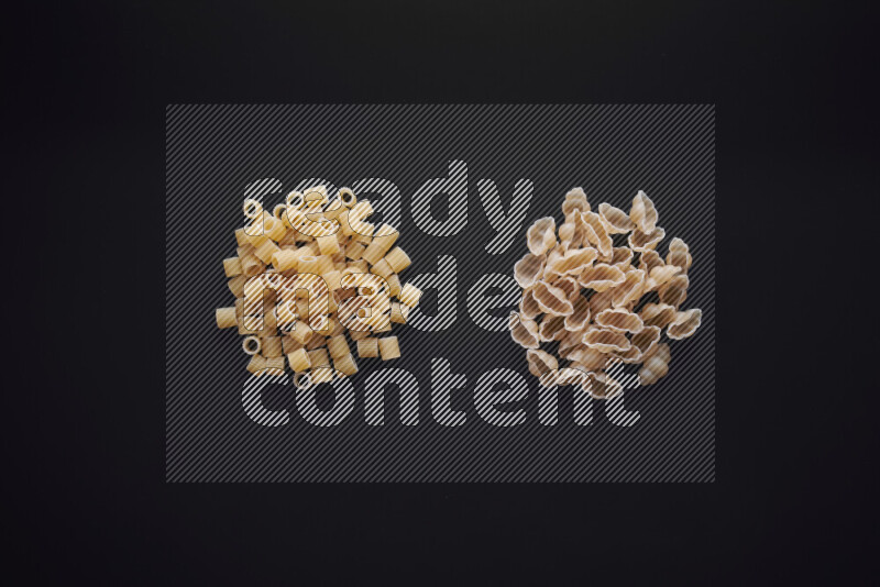 Different pasta types in bunches on black background