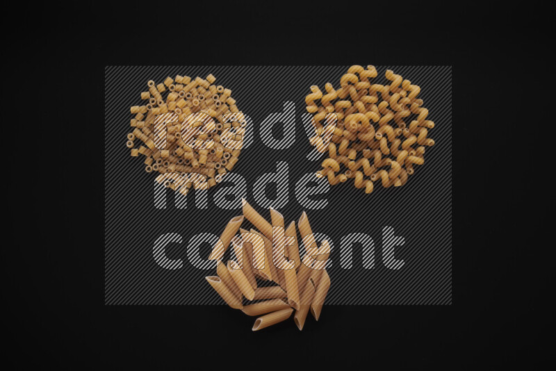 Different pasta types in bunches on black background