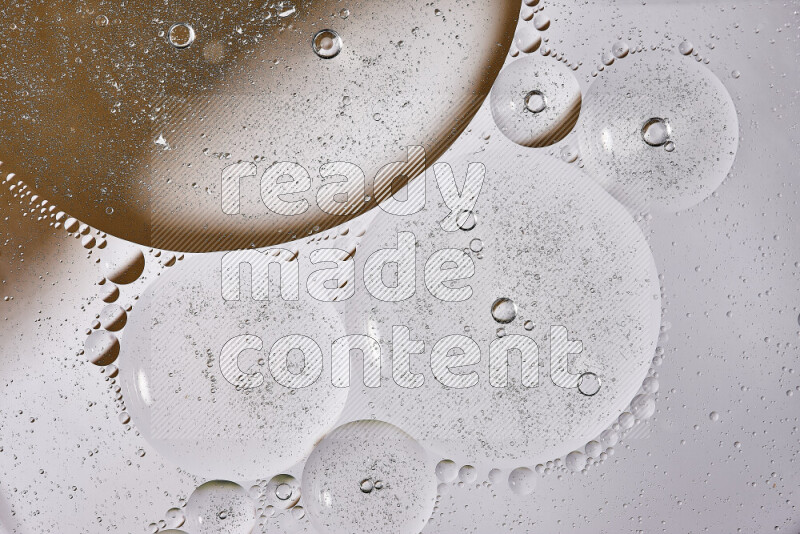 Close-ups of abstract oil bubbles on water surface in shades of white and brown