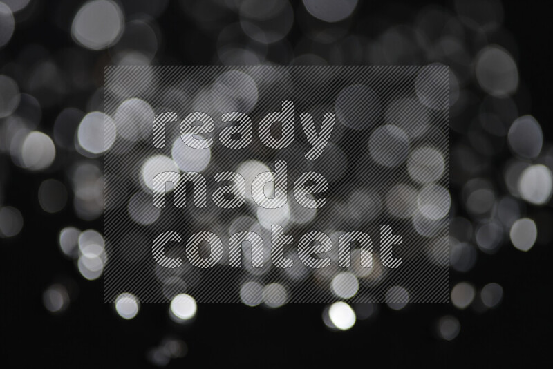 قطع زجاجية فضية لامعة متناثرة على خلفية سوداء