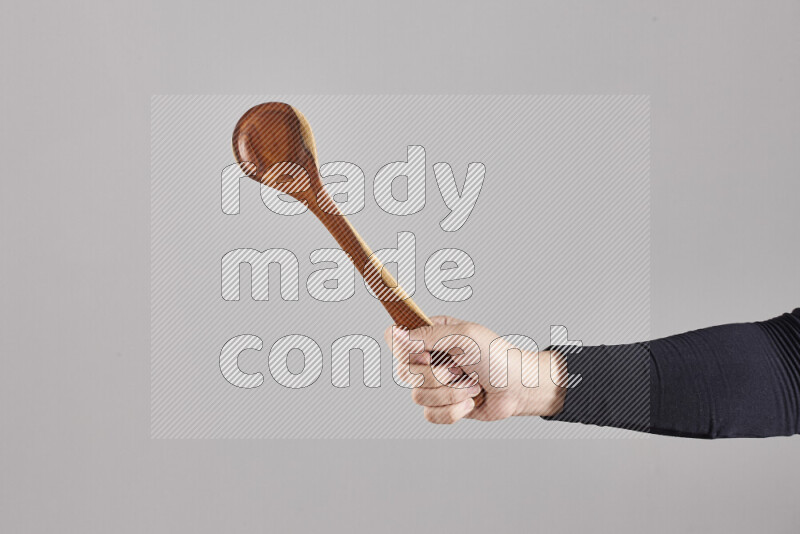 A woman in black abaya holding different wooden essentials in different positions